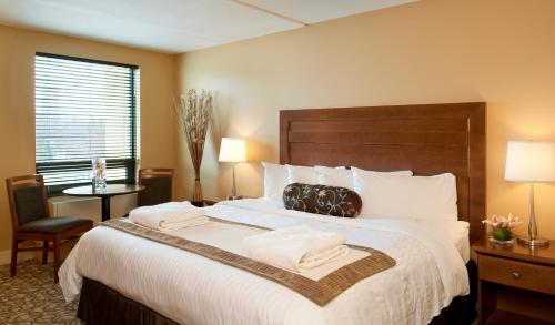 a hotel room with a large bed with two pillows at Temple Gardens Hotel & Spa in Moose Jaw