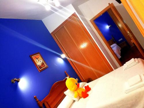 a bedroom with a stuffedanimal sitting on a bed at Hostal Restaurante Ego's in Campo de Criptana