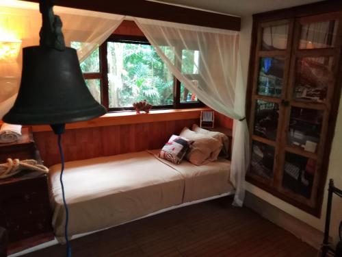 a bedroom with a bed with a lamp and a window at Jungle Lodge CANCUN AEROPUERTO in Cancún