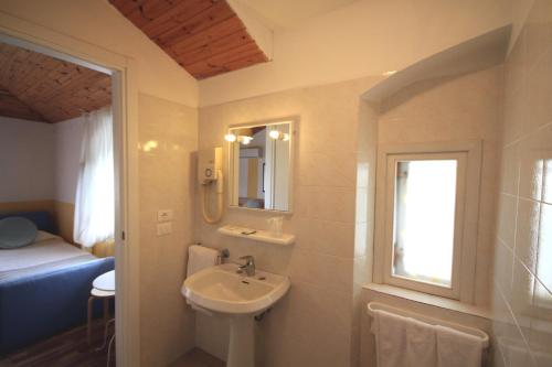 a bathroom with a sink and a mirror at Albergo Villa Gradita in Forte dei Marmi