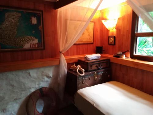 a small bedroom with a bed and a window at Jungle Lodge CANCUN AEROPUERTO in Cancún
