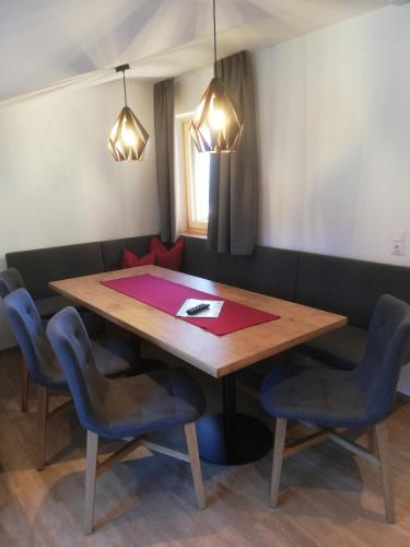 a dining room with a wooden table and blue chairs at Pension Edelweiß in Sankt Johann im Pongau