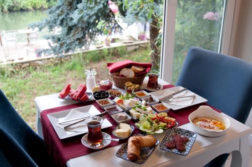 a table with food on it with a window at Agva Nehir Evi - Adult Only in Agva