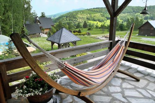 a hammock sitting on a patio with a view at Domy wakacyjne Familia in Duszniki Zdrój