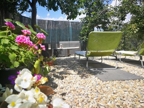 a patio with a green chair and some flowers at Agriturismo Nonni Devia in Lucinasco