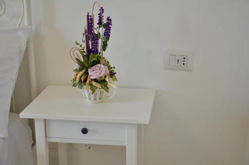 a vase with flowers on a white table at Relais Bellavista B&B in Casalnuovo di Napoli