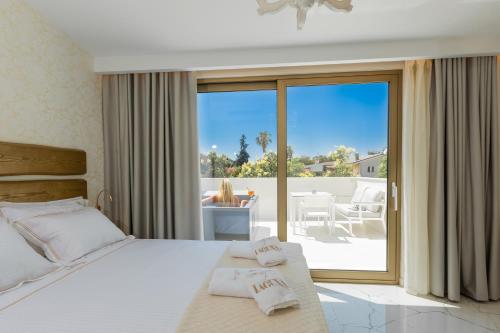 a bedroom with a bed and a view of a patio at Laguna Resort Boutique Hotel in Hanioti