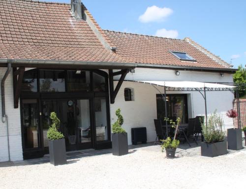 a building with potted plants in front of it at La Ferme de la Place in Bouvines