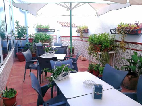 an outdoor patio with tables and chairs and plants at Hostal Restaurante Ego's in Campo de Criptana
