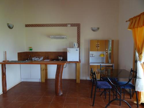 a kitchen and dining room with a table and a refrigerator at Cabañas Rapa Nui Orito in Hanga Roa