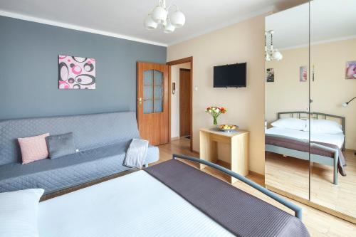 a hotel room with a bed and a tv at Sleepy3city Slaska 31 in Gdynia