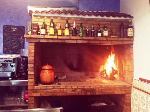 a fireplace with a bunch of bottles of wine at Hostal Restaurante Ego's in Campo de Criptana