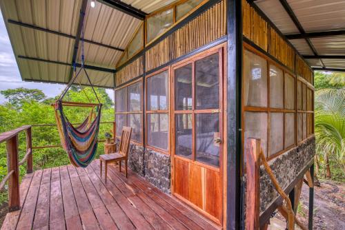 a house with a hammock on a wooden deck at La Bambouseraie in Balgue
