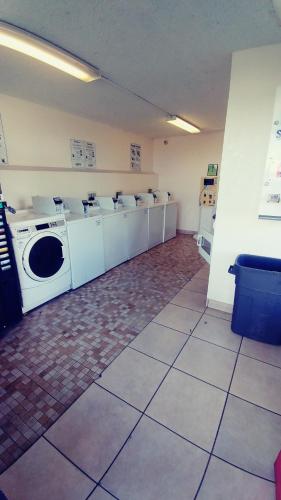 a laundry room with a row of washing machines at InTown Suites Extended Stay Select Orlando FL - Lee Rd in Orlando
