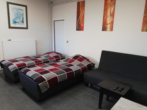 a living room with a bed and a couch at Lommel-inn in Lommel