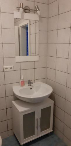 a bathroom with a white sink and a mirror at FEWO Familie Hentschel in Rambin