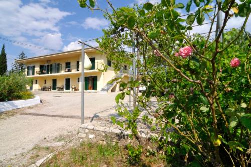 a building with a lot of flowers in front of it at anastasios paleokastritsa studios in Doukádes