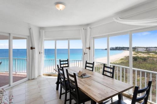 a dining room with a table and views of the ocean at Turtle's Nest Beach Resort in Meads Bay