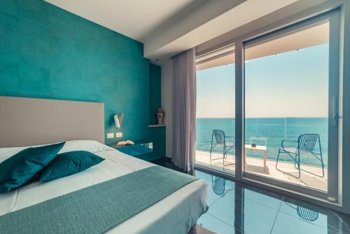 Nautilus Hotel في جيارديني ناكسوس: غرفة نوم مع سرير وإطلالة على المحيط
