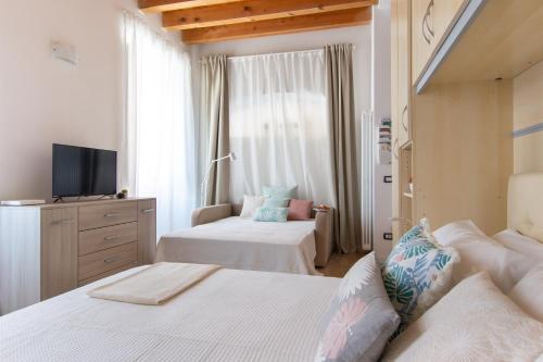 een slaapkamer met 2 bedden en een televisie. bij Foresteria della Corte in Como