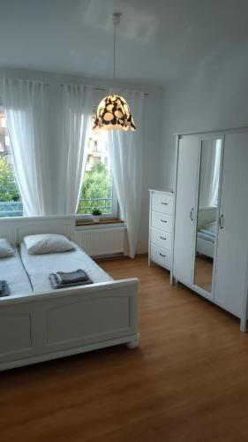 コウォブジェクにあるDOBRUK APARTAMENTY Apartament na Osiedlu Bajkowymのベッドルーム1室(ベッド1台、ドレッサー、鏡付)