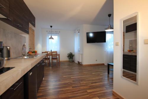 kuchnia z drewnianą podłogą i blatem kuchennym w obiekcie ApartDębki w mieście Odargowo