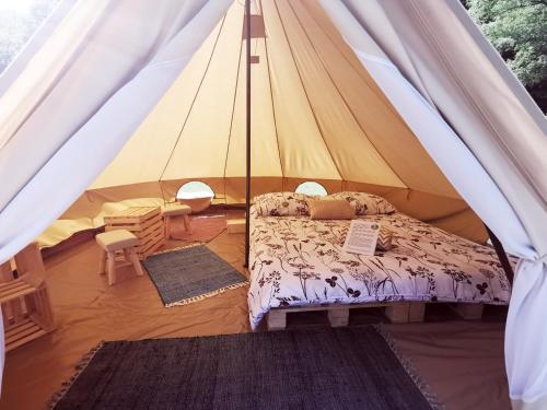 1 dormitorio con 1 cama en una tienda de campaña en ECO River Camp en Radovljica