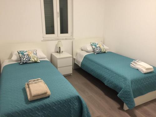 een slaapkamer met twee bedden en een raam bij Villa Olea in Punat