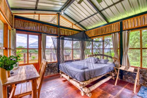 a bedroom with a bed in a room with windows at La Bambouseraie in Balgue