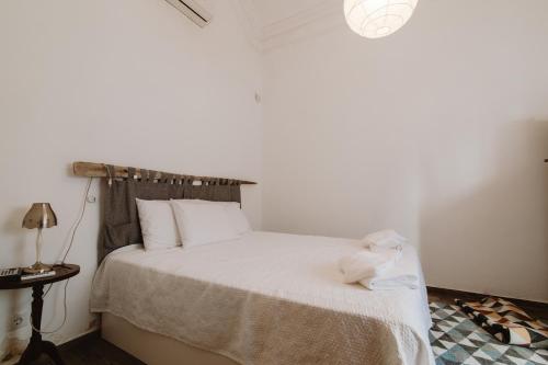 una camera con letto e tavolo con lampada di Fernanda's House a Olhão