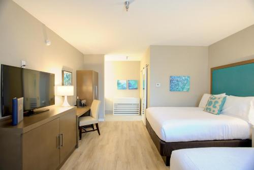 Beachview Club Hotel في جزيرة جيكل: غرفة فندقية بسرير وتلفزيون بشاشة مسطحة