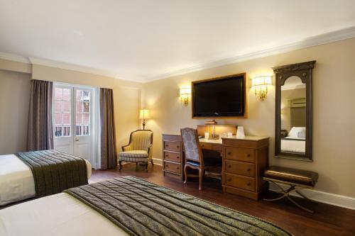 a hotel room with a bed and a desk and a mirror at Hotel St. Marie in New Orleans