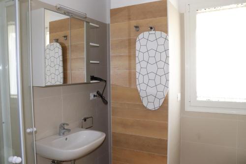 uma casa de banho com um lavatório e um espelho em Antares em Riccione