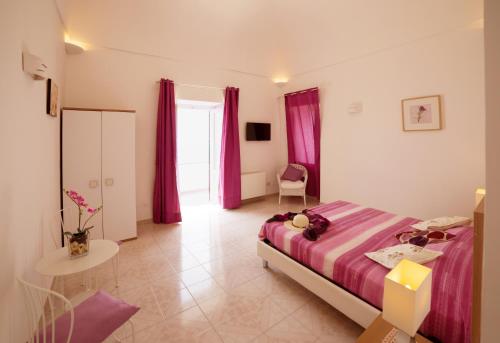 a bedroom with a large bed and purple curtains at Villa Marilisa in Conca dei Marini