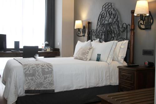 a bedroom with a large white bed with a black headboard at Zocalo Central in Mexico City