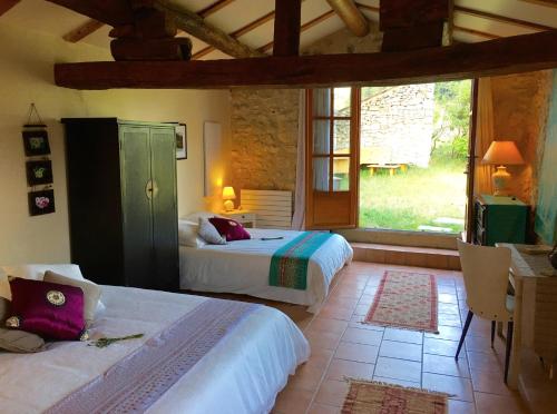 a bedroom with two beds and a large window at Le Jas du Mont Ventoux in Sault-de-Vaucluse