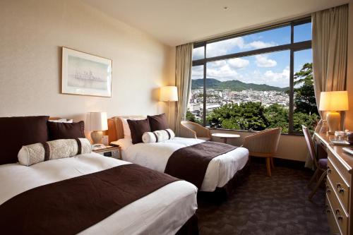 a hotel room with two beds and a large window at Gamagori Classic Hotel in Gamagōri