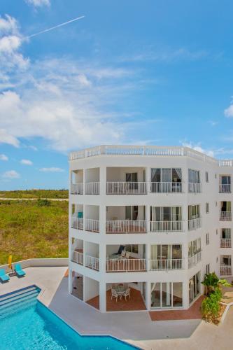 a building with a swimming pool and a resort at Turtle's Nest Beach Resort in Meads Bay