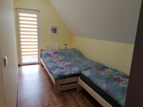 a bedroom with two beds and a window at Domki pod Derkaczem in Wünschelburg