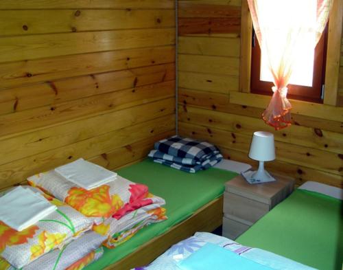 a room with a bed in a wooden cabin at Domki LaPlata na Kaszubach in Wiele