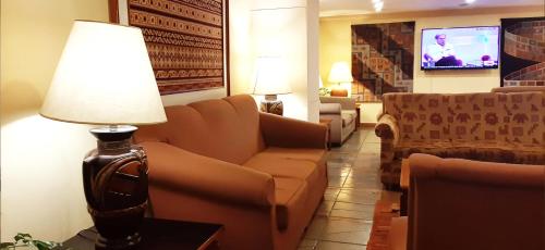 a living room with a couch and a lamp at Hotel Gloria La Paz in La Paz