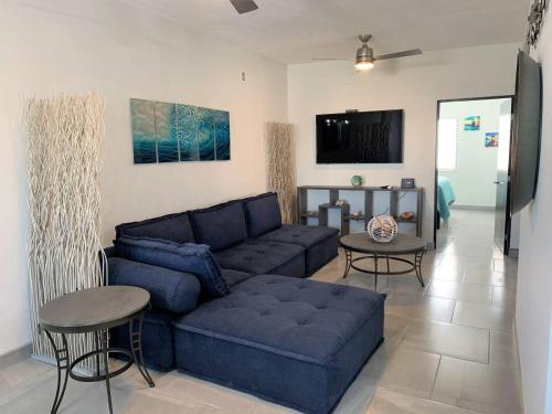 a living room with a blue couch and a table at Casita de Moana in Puerto Peñasco