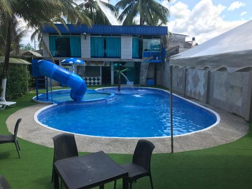 a pool with a slide in the middle of a house at Hotel La Cascada - Lago Agrio in Nueva Loja