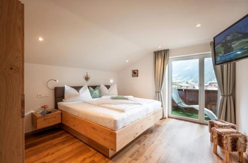 sypialnia z dużym łóżkiem i dużym oknem w obiekcie Haus Schlechter w Mayrhofen