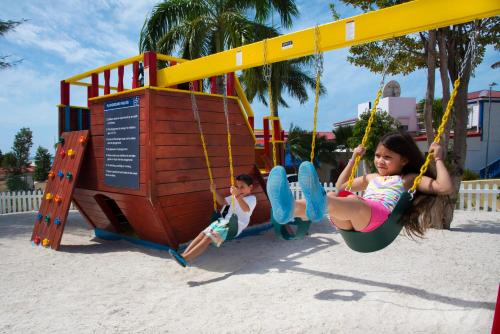 two children playing on a swing set at a playground at Simpson Bay Resort Marina & Spa in Simpson Bay