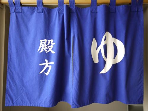 a blue curtain with chinese characters on it at Hotel Route-Inn Osaka Honmachi in Osaka