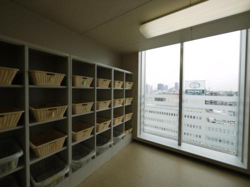 a library with shelves and a window with a view at Hotel Route-Inn Osaka Honmachi in Osaka