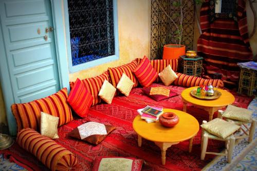 a living room with a red couch and two tables at Riad Al Nour in Marrakech