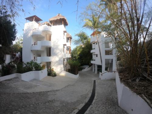a white apartment building with a pathway leading to it at Mar y Sueños in Sayulita