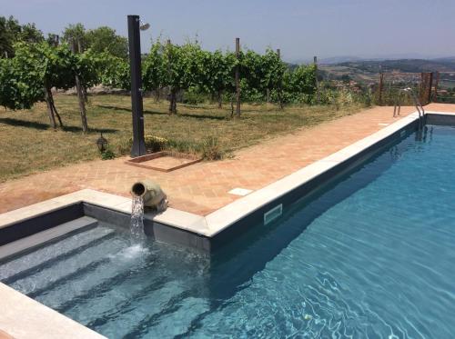 a bear laying in the water next to a swimming pool at Relais de Beaumont in Castelvetere sul Calore